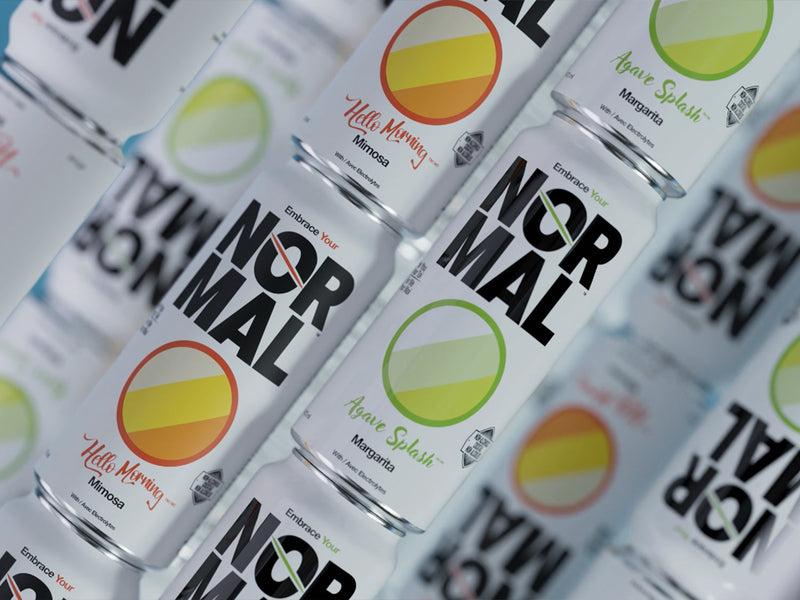 Overhead flat-lay of Normal Hello Morning Mimosa and Agave Splash Margarita cans arranged in a tight diagonal pattern, alternating flavor and orientation.